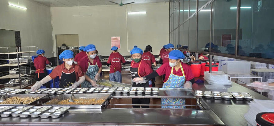 Nhân viên Công ty CP Hồng Đức chia cơm cho học sinh học bán trú trên địa bàn TP Cẩm Phả.