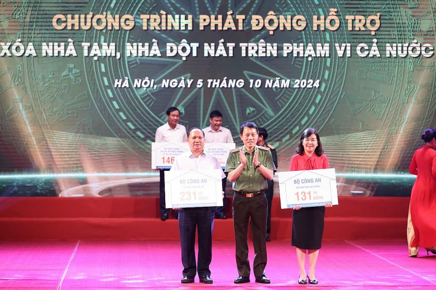 Bộ trưởng Bộ Công an Lương Tam Quang trao kinh phí của Bộ Công an ủng hộ các địa phương xoá nhà tạm, nhà dột nát - Ảnh: VGP