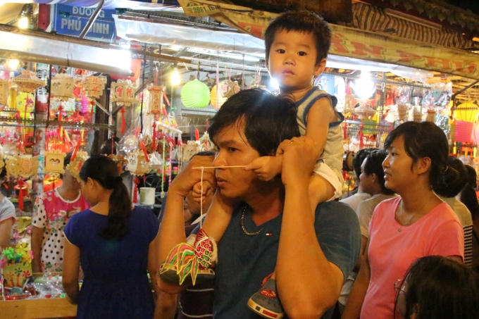 Sau một buổi tối chen lấn trong biển người, cậu bé này cũng đã có được món quà được bố mua cho. Một chiếc lồng đèn hình con cá.