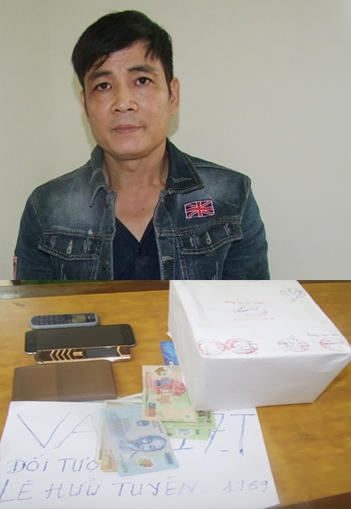 Lê Hữu Tuyên cùng tang vật vụ án. (Ảnh: báo Nhân dân)