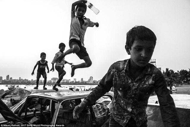 Ảnh chụp ở vịnh Mahim, Mumbai, Ấn Độ. Một nhóm trẻ chơi trong bãi chứa xe phế thải.