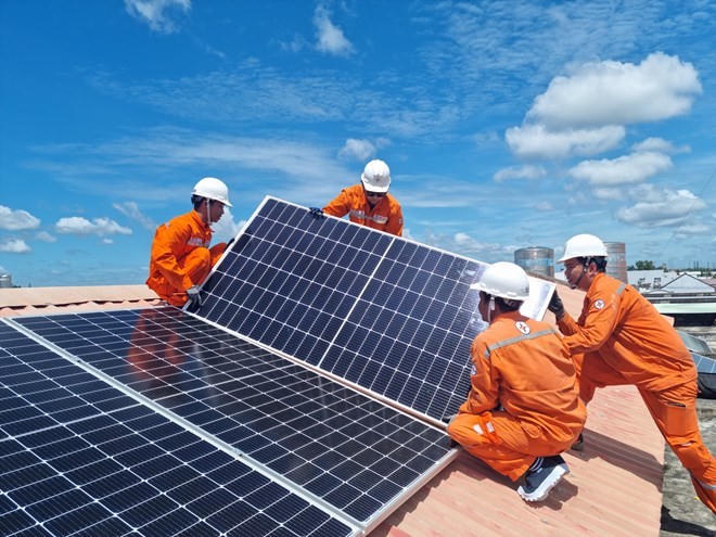 Công nhân Tổng Công ty Điện lực TP HCM lắp đặt hệ thống điện mặt trời trên mái nhà.