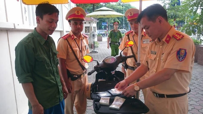 Lực lượng CSGT phát hiện chiếc cặp chứa 70 triệu đồng cùng nhiều giấy tờ tùy thân.