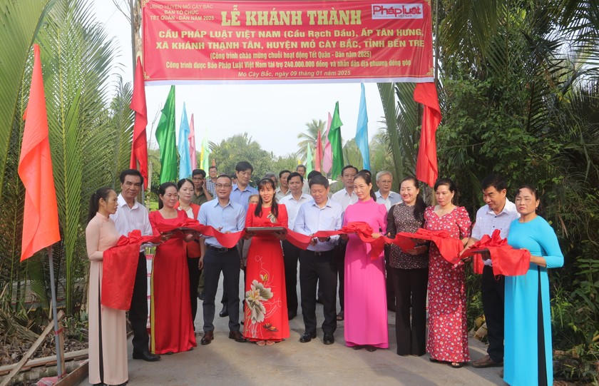 Lãnh đạo địa phương và lãnh đạo Báo Pháp luật Việt Nam thực hiện nghi thức khánh thành cầu.