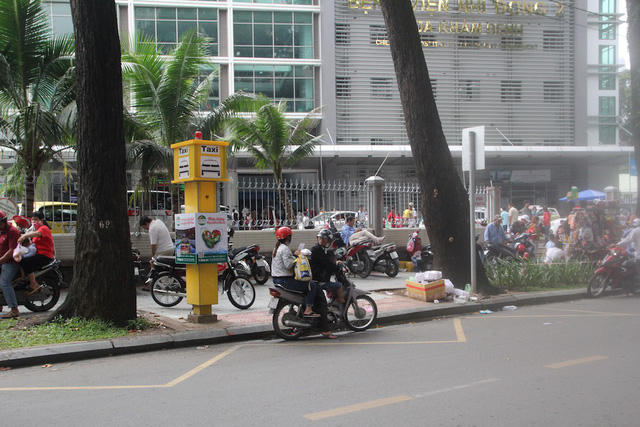 Điểm đón taxi có trụ báo taxi màu vàng và phần vạch kẻ cho phép dừng xe 2 phút.