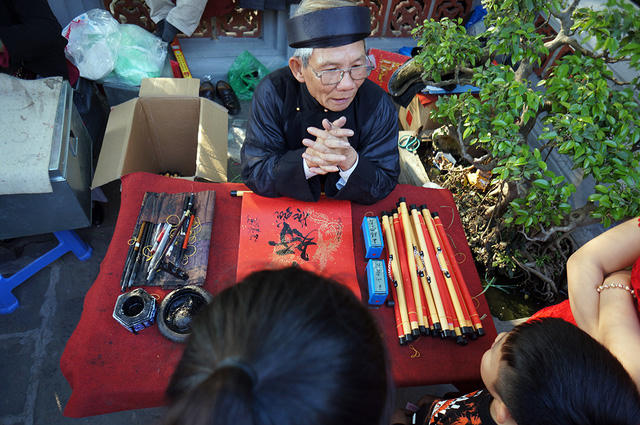 Nhiều người tranh thủ xin chữ đầu năm mới ngay trong sân đền để cầu may mắn, thành công.