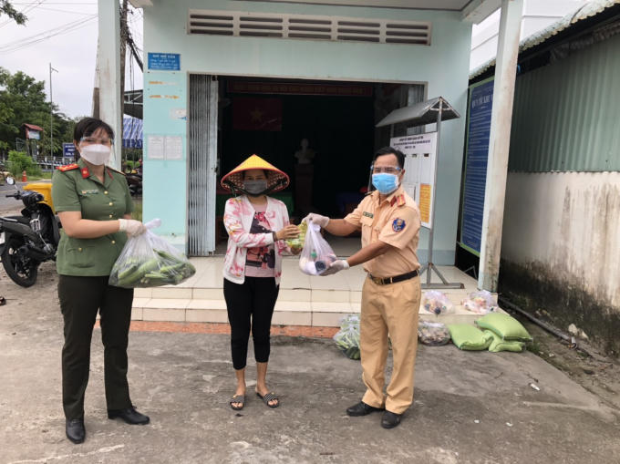 Đc đại uý Lê Thanh Bình bí thư đoàn thanh niên công an quận và đc đại uý Nguyễn Việt Nhân chủ tịch hội phụ nữ công an quận trao quà cho bà con ở phường Long Hưng quận Ô Môn Tp Cần Thơ