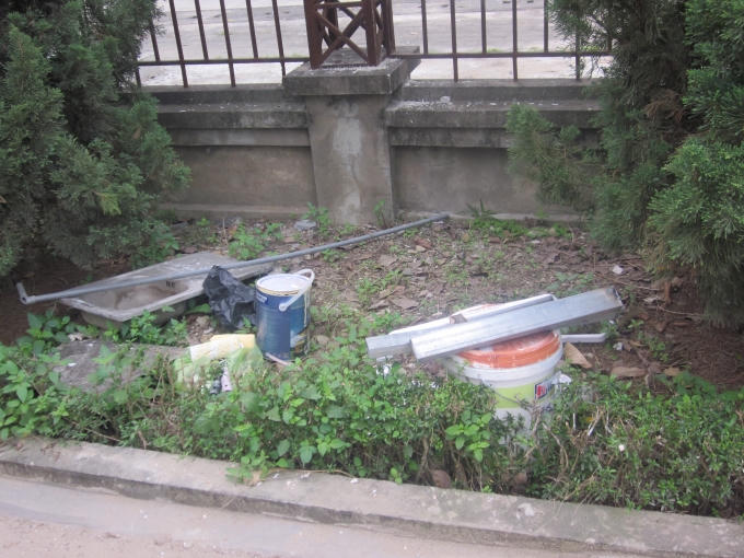 Ở chân tường sát cổng ra vào.