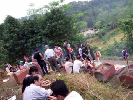 Nhiều gia đình bày mâm cúng bên những ngôi mộ của người thân đã khuất. (Ảnh: Người đưa tin)