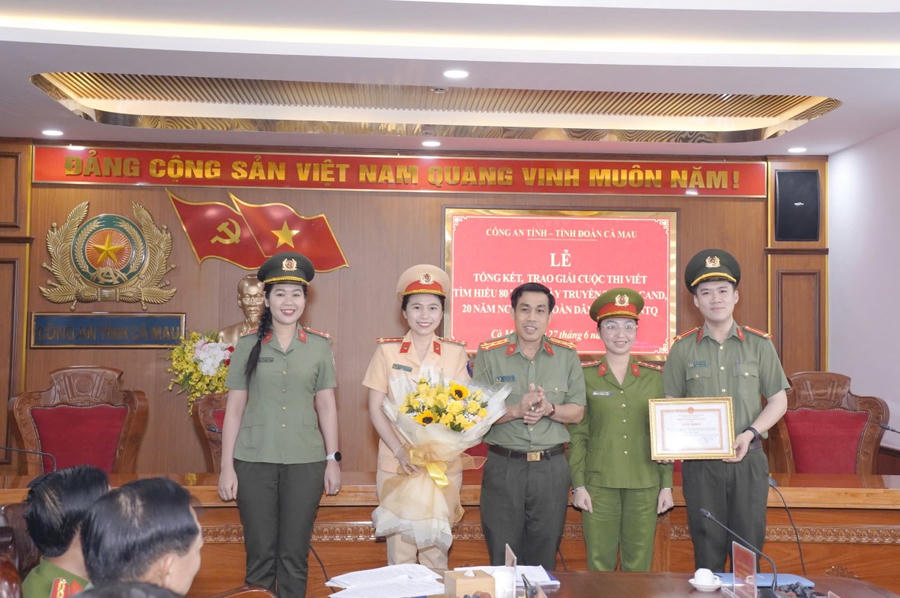 Đại tá Lê Tấn Vinh - Phó Giám đốc phụ trách Công an tỉnh Cà Mau, trao Giải Nhất cho nhóm tác giả.