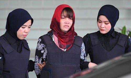 Cảnh sát áp giải Đoàn Thị Hương (giữa) rời tòa án ở Kuala Lumpur, Malaysia hôm 14/3. Ảnh: AFP.