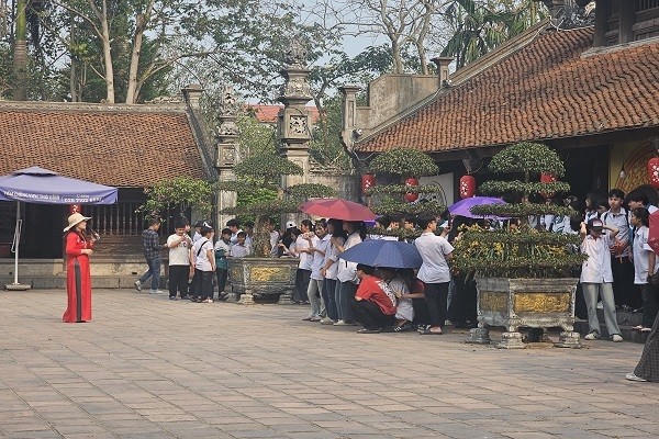 Cán bộ phòng văn hóa thông tin huyện Hưng Hà giới thiệu về khu di tích cho các các em học sinh.
