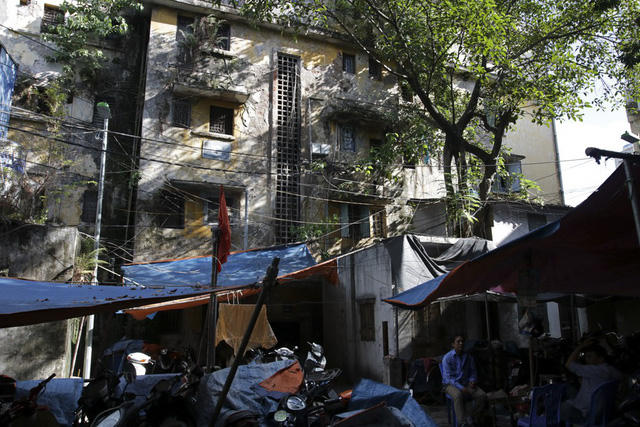 Dãy nhà C tập thể Nguyễn Công Trứ với tường bao bị hư hỏng nặng, trên mảng tường bong tróc là những cây tầm gửi cắm rễ khiến cho nó lúc nào cũng có vẻ ẩm ướt.