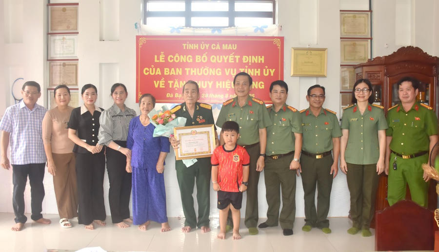 Đại tá Hồ Việt Triều - Ủy viên Ban Thường vụ Tỉnh ủy, Bí thư Đảng ủy, Giám đốc Công an tỉnh Cà Mau, trao Huy hiệu 60 năm tuổi Đảng cho đồng chí Phạm Hữu Hạp.