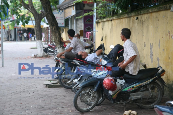 Một ông bố ung dung ngả lưng trên yên xe máy.