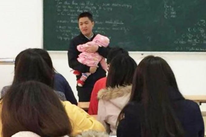 Bức ảnh giảng viên bế con cho nữ sinh làm bài thi "gây bão" cộng đồng mạng những ngày qua. Ảnh: FB