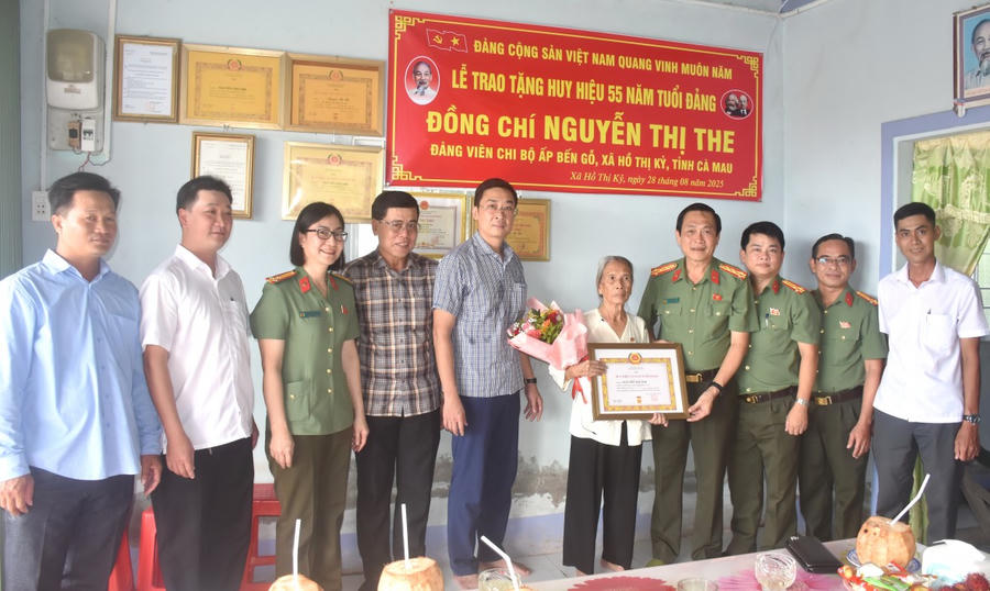 Đại tá Hồ Việt Triều, trao Huy hiệu 55 năm tuổi Đảng cho đồng chí Nguyễn Thị The.