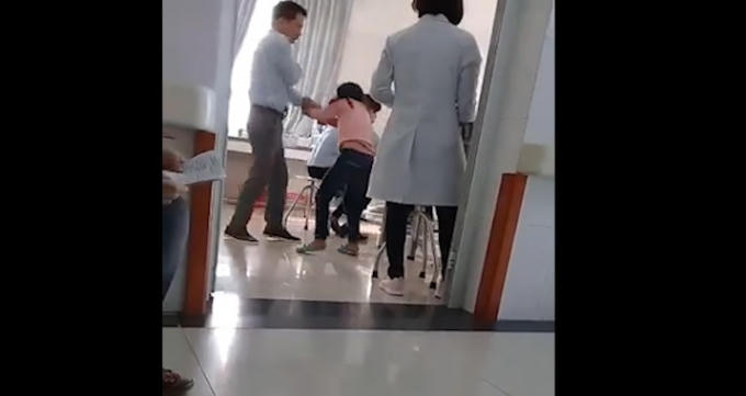 Bé gái bị bố bạo hành ngay khu vực khám bệnh của bệnh viện. Ảnh: Cắt từ clip.