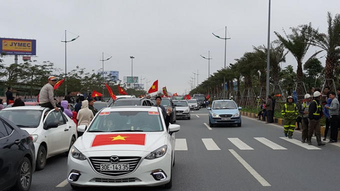 Hàng nghìn người hâm mộ với cờ đỏ sao vàng tại nhiều tuyến phố Hà Nội chờ đón những "người hùng" U23