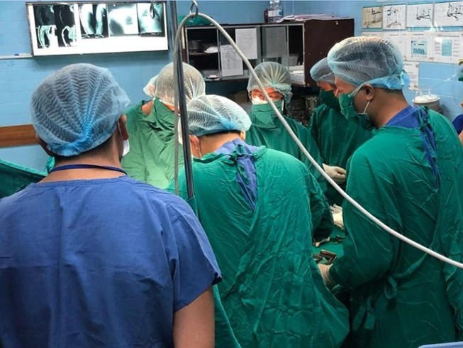 Bác sĩ của hai bệnh viện đang phẫu thuật cứu cánh tay phải anh M. Ảnh: HÒA KHÁNH