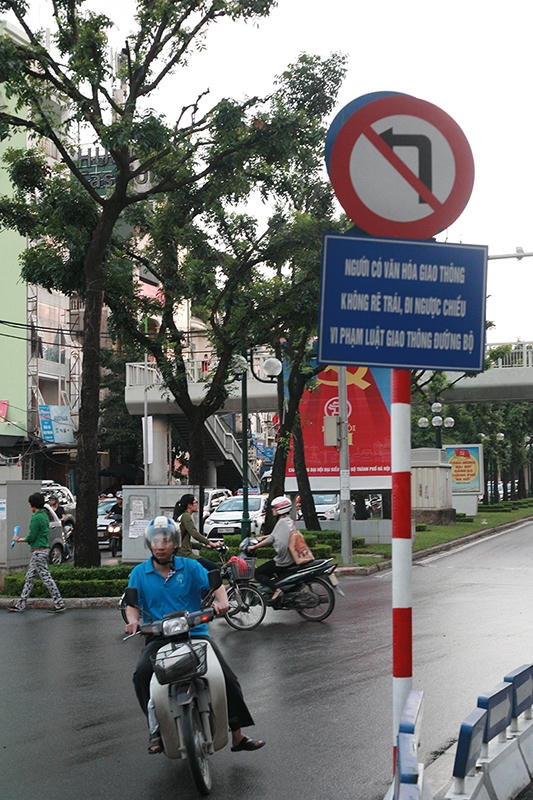 Tấm biển cảnh báo rất to trên phố Giảng Võ nói về "văn hoá" giao thông và ngay bên dưới người dân thích thì vẫn cứ... đi.