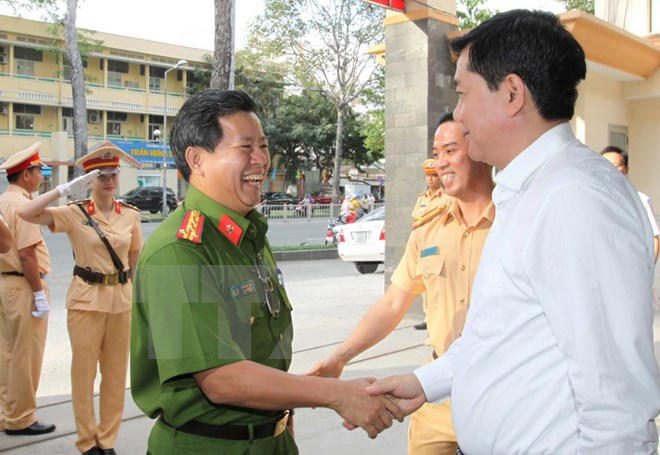 Ông Đinh La Thăng với cán bộ, chiến sỹ Phòng Cảnh sát giao thông đường bộ đường sắt. (Ảnh: Thanh Vũ/TTXVN)