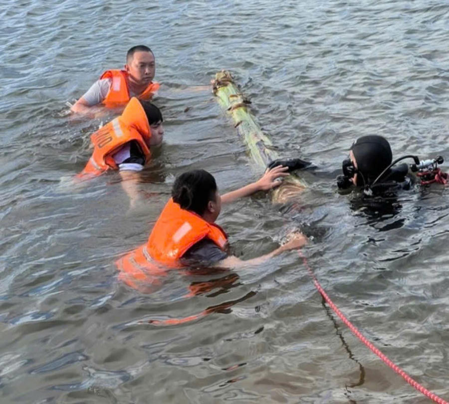 Người dân phối hợp với Lực lượng chức năng tìm kiếm thi thể 2 em học sinh đuối nước. Ảnh TĐ