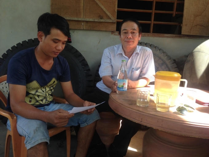 Anh Long vui vẽ bàn giao laị chai nước cho ông Trần Hữu Hóa với mong muốn tìm ra nguyên nhân và khắc phục để tránh ảnh hường đến người tiêu dùng. Ảnh: Văn Ba.