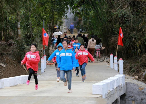 Các em học sinh vui đùa trên cây cầu mới