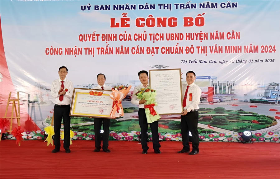 Ông Lượng Trọng Quyền - Bí thư Huyện ủy Năm Căn (bên trái) và ông Võ Văn Hành - Phó Chủ tịch UBND huyện Năm Căn (bên phải) trao Quyết định và Bằng công nhận thị trấn Năm Căn đạt chuẩn đô thị văn minh.