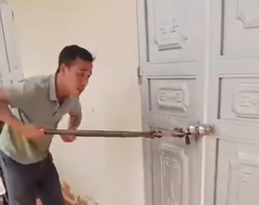 Phụ huynh dùng kìm phá khóa đưa học sinh bị bỏ quên trong lớp học ra ngoài. Ảnh: MXH.