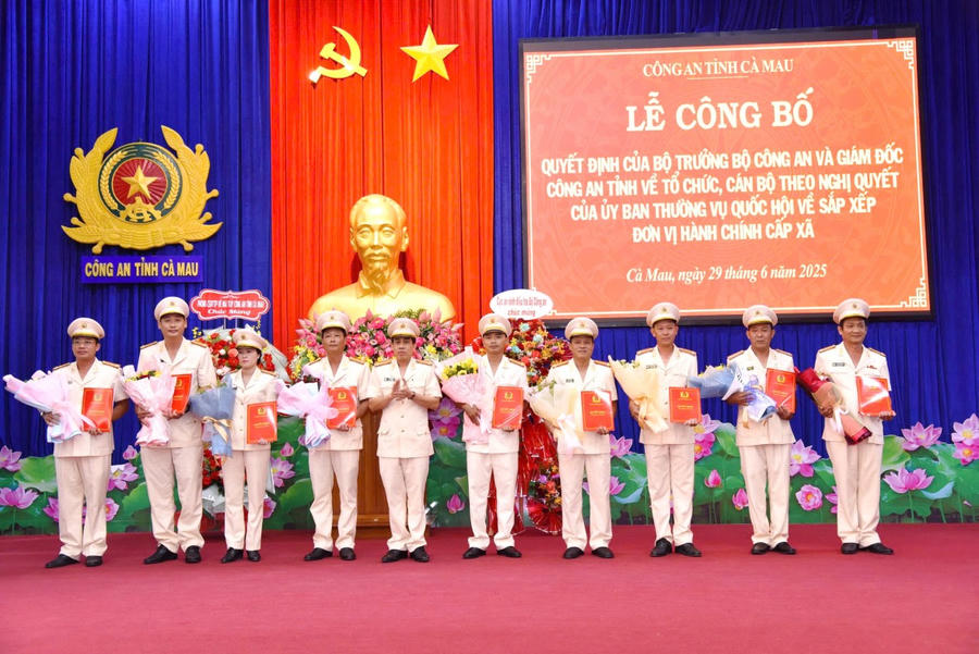 Đại tá Lê Tấn Vinh - Phó Giám đốc Công an tỉnh Cà Mau, trao quyết định và tặng hoa chúc mừng các Trưởng Công an xã.
