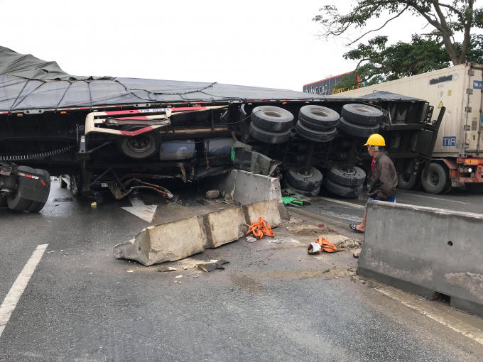 Chiếc xe container lật ngang trên quốc lộ 1A sau cú đánh lái tránh chiếc xe máy do một người phụ nữ điều khiển.