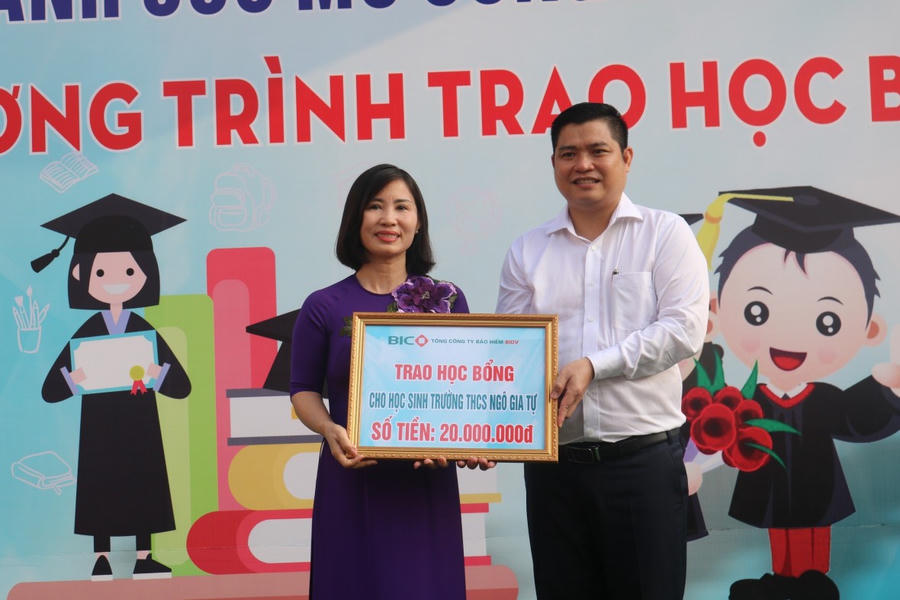 Giám đốc Công ty Bảo hiểm BIDV Miền Đông Trịnh Ngọc Kiên trao quà cho lãnh đạo nhà trường.