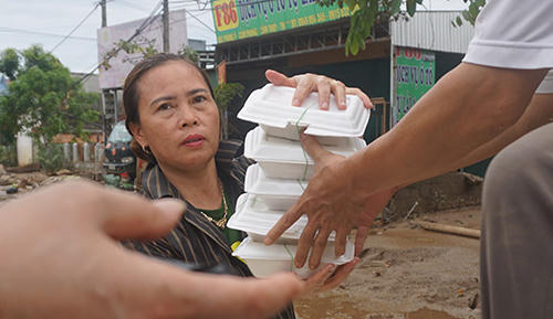 Đều đặn hai bữa mỗi ngày, người dân vùng lũ ở Cẩm Phong được phát cơm miễn phí đến tận nhà, giúp họ qua cơn đói. Ảnh: Lê Hoàng.