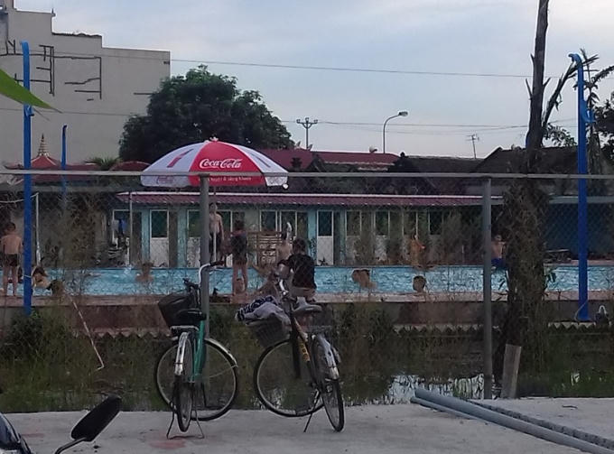 Thời điểm chiều ngày 6/7 và ngày 7/7 thời tiết âm u và có sấm sét nhưng hàng chục người vẫn "vô tư" tắm tại bể bơi này (Ảnh Nguyễn Xinh).