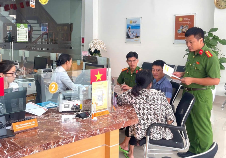 Cán bộ Công an xã Lục Nam phối hợp nhân viên ngân hàng tuyên truyền phương thức thủ đoạn lừa đảo của đối tượng cho công dân. (Ảnh: Bộ Công an)