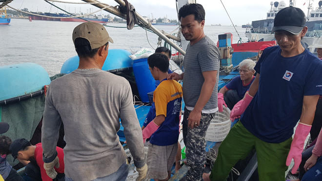 Anh Viện (thứ 2 từ phải qua) đứng cùng bạn thuyền đưa cá lên bờ.