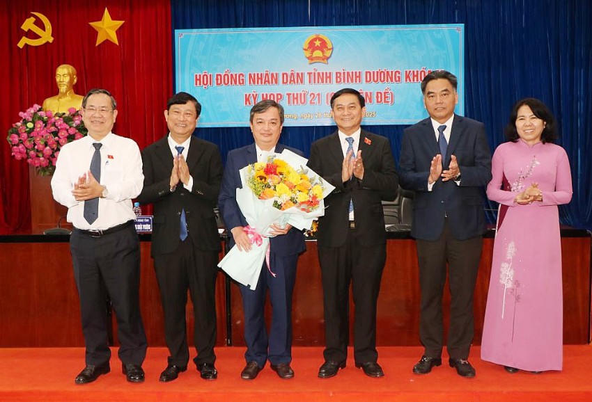 Lãnh đạo tỉnh tặng hoa chúc mừng ông Bùi Minh Trí. Ảnh: Báo Bình Dương