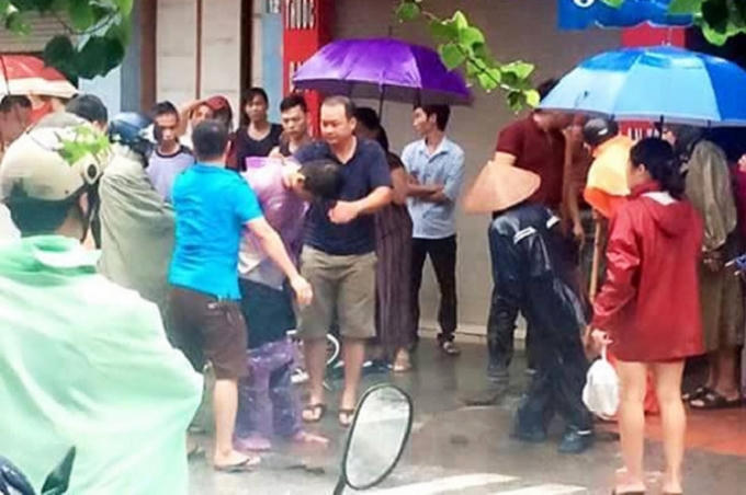 Đối tượng Tri bị người dân khống chế sau khi gây án.