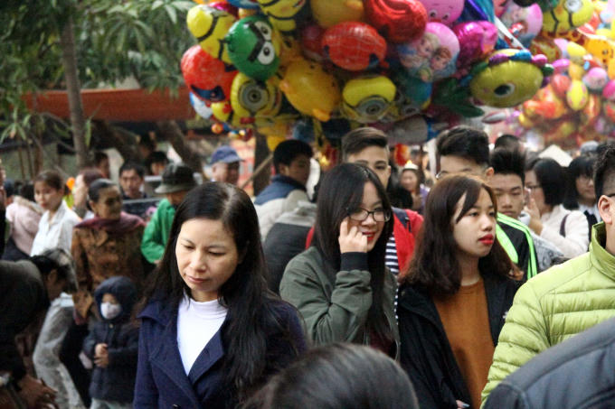 Dọc con phố Quan Nhân dẫn vào đình làng Quan Nhân, hàng nghìn người, đa số là thanh niên và trẻ nhỏ nô nức mua sắm quà Tết.