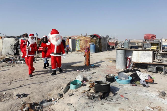 Các tình nguyện viên từ thiện phát quà ở những khu dân cư nghèo ở Iraq. (Ảnh: Reuters)