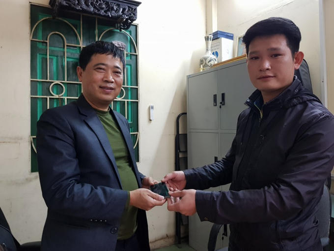 Anh Nguyễn Anh Tuấn (bìa phải), vui mừng nhận lại tài sản của mình từ lãnh đạo Đội TTGT quận Hoàn Kiếm.