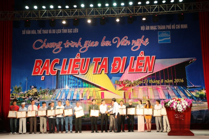 Ông Vương Phương Nam - Phó Chủ tịch UBND tỉnh tặng bằng khen các tập thể và cá nhân có đóng góp cho phong trào âm nhạc của tỉnh Bạc Liêu. (Ảnh: Nguyên Hoàng)