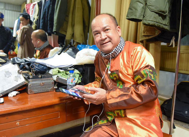 Nghệ sĩ Hoàng Sơn nhẩm lại thoại trước khi bước ra sân khấu. Vì lạnh nên nam nghệ sĩ phải mặc kín mít và ngồi yên vì một chỗ ở một góc phòng hoá trang.