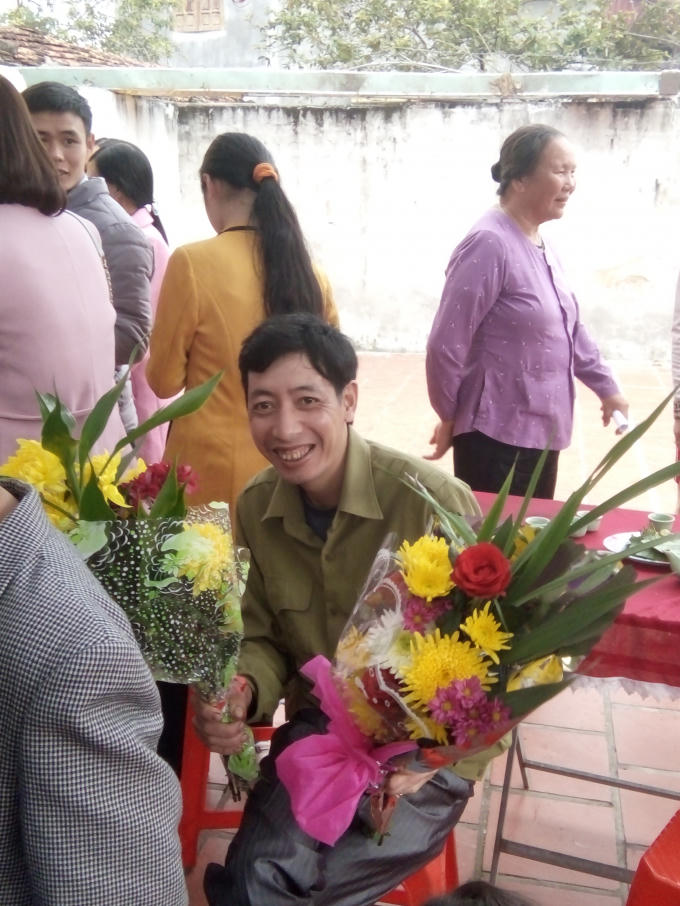 Nụ cười của một người con được ôm hoa chúc mừng thọ bố mẹ.