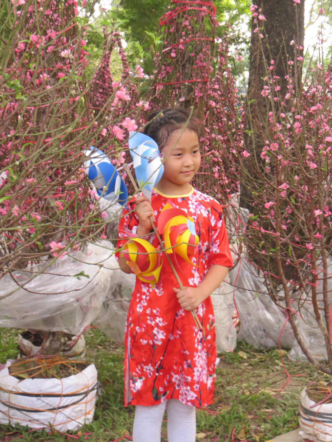 Các em nhỏ được bố mẹ trưng diện quần áo tham quan chợ hoa.