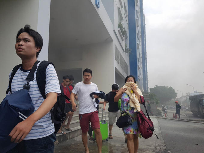 Trong vụ cháy ở chung cư Carina Plaza, nhiều người dùng khăn ướt bịt mũi để tránh khói độc NGỌC DƯƠNG