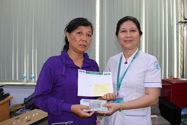 Đại diện bệnh viện trao món tiền bạn đọc giúp gia đình thông qua Báo Dân trí tuần 1 và 2 tháng 3