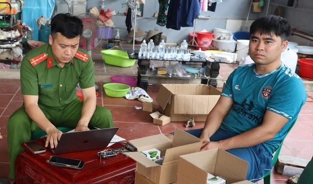Nguyễn Văn Khánh làm việc với cơ quan công an tại thời điểm bị phát hiện sản xuất mỹ phẩm giả.